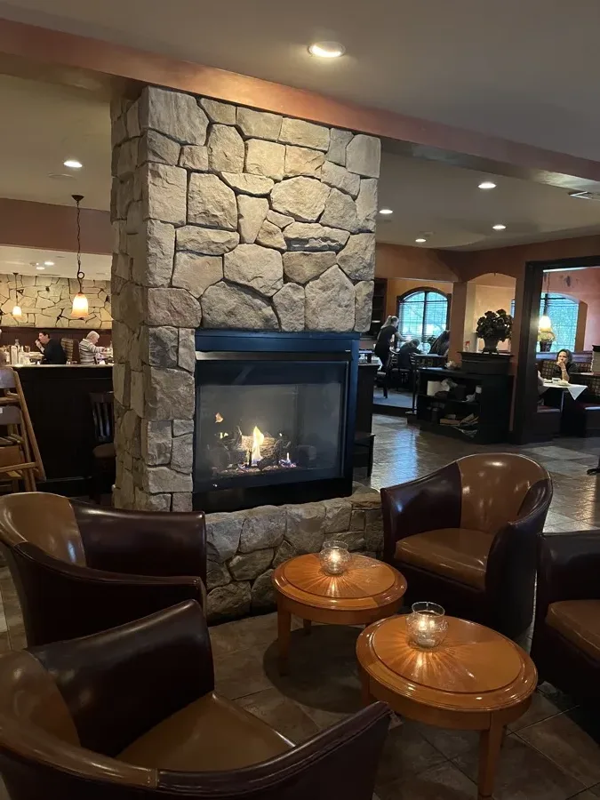 Stone fireplace lounge seating at Amari Bar and Ristorante